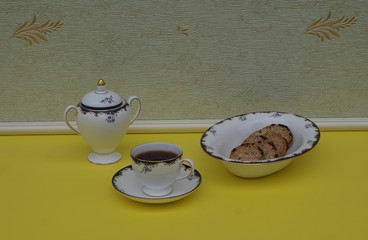 English teacup with saucer, sugar bowl and a cake bowl with cookies, fine bone china porcelain