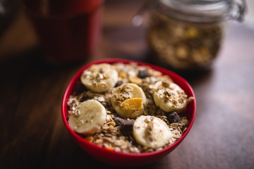 banana with cereals in a red bowl