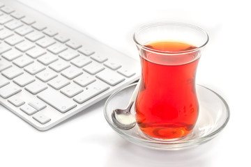 White keyboard and turkish tulips tea glass