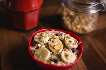 banana with cereals in a red bowl