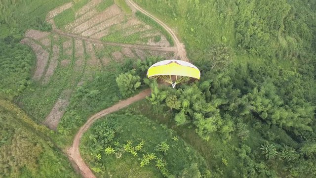 Flying high above a paraglider magestically flying over a beautiful valley in Phetchabun Thailand