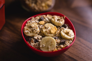 banana with cereals in a red bowl