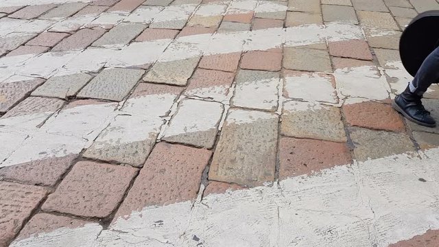 Few people crossing cobblestone road on zebra, traffic violation, safety concept