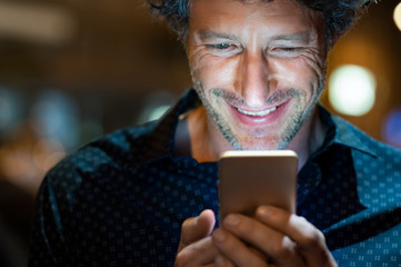 Man checking smartphone at night