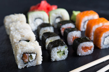 A variety of sushi and rolls on a dark background