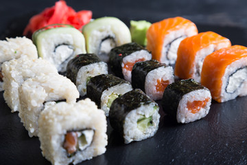 A variety of sushi and rolls on a dark background