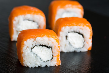 A variety of sushi and rolls on a dark background