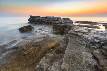 Enjoying the colorful sunset on a beach with rocks on the Adriatic Sea coast Istria Croatia