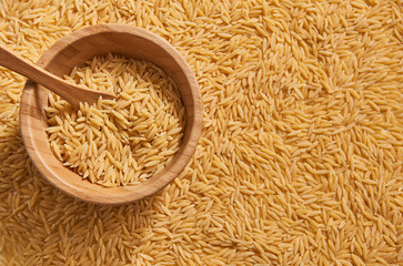 Many raw barley noodle wooden plate and wooden spoon.