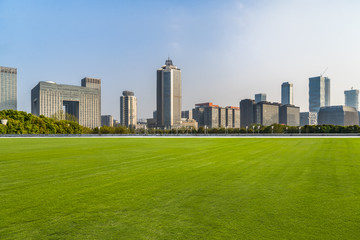 cityscape and skyline of shanghai from meadow in park.