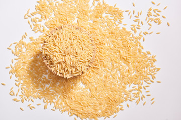 Many raw barley noodle and wooden plate on the white table.
