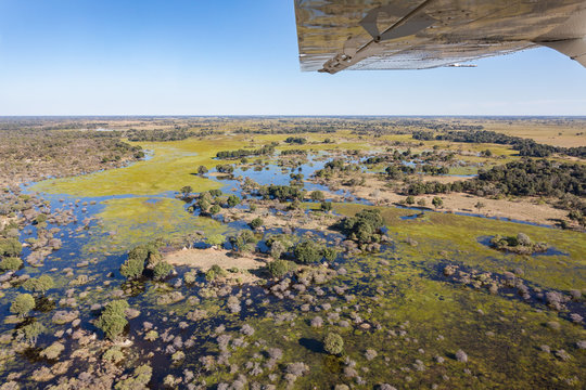 rundflug &uuml;ber okavango delta in botswana afrika mit einem teil der tragfl&auml;che vor blauen himmel im tiefflug