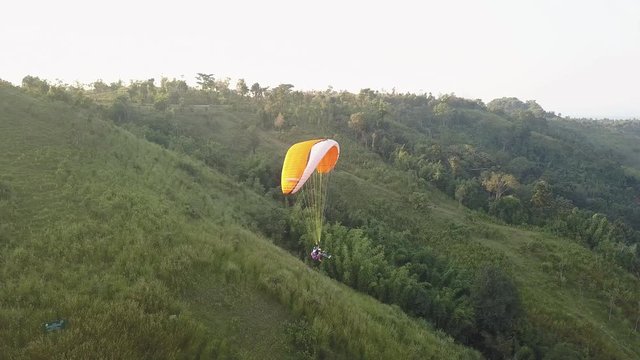 Two people having fun in tandem paragliding overlooking an amazing valley in beautiful Phetchabun Thailand