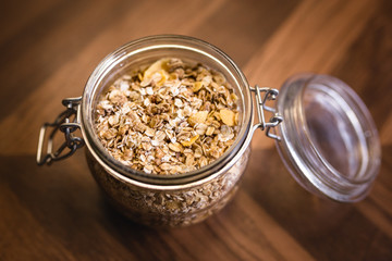 Glass jar with various seeds, oats and cereal.