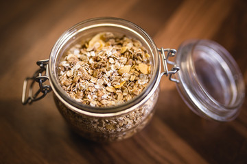 Glass jar with various seeds, oats and cereal.