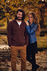 Couple in autumn season colored park enjoying outdoors.