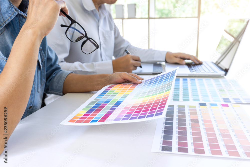 Fototapete team of colleague graphic designer drawing and retouching image on graphics tablet and choose color 