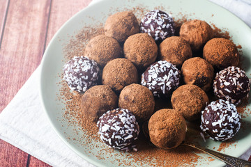Homemade chocolate truffles with cocoa and coconut on the plate