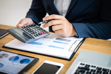 Businessman hands using text information on digital tablet to analyze financial statistical chart data and calculate cost of investment project