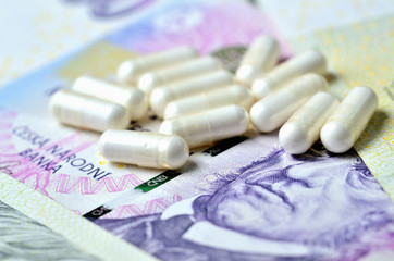 Pills on Czech banknotes - concept of healthcare and finance