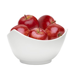 Red apples in white porcelain bowl isolated on white background