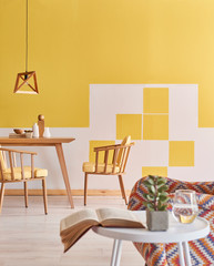 Close up coffee table and armchair decoration, yellow and white wall wooden furniture.
