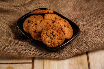 Oatmeal cookies on a black plate. The concept of natural and delicious food.