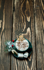 cup of hot cocoa with marshmallow, cookies, fir-tree on wooden background
