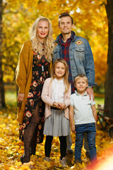 Fototapeta premium Image of young parents and children on walk in autumn park