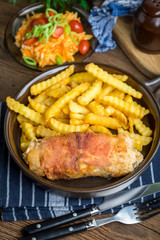 Fried chicken breast stuffed with mushrooms and cheese wrapped in ham served with fries and salad.