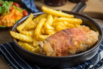 Fried chicken breast stuffed with mushrooms and cheese wrapped in ham served with fries and salad.