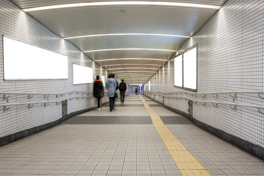 The walkway interior building connects to the subway with blank billboard on white screen background.
