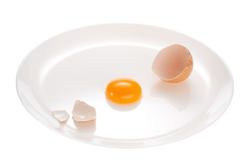 Broken chicken egg on a white plate. Isolated on white background.