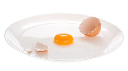 Broken chicken egg on a white plate. Isolated on white background.