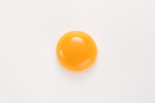 Raw egg yolk on a white background. View from above.