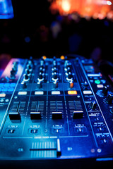 Dj mixes the track in the nightclub at party. In the background laser light show