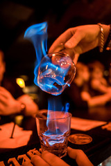 The bartender strains a cocktail in a glass at a nightclub, beach, pub, restaurant