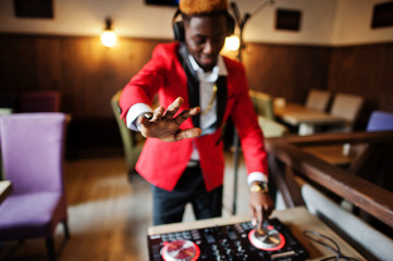 Fototapeta na wymiar Fashion african american man model DJ at red suit with dj controller.