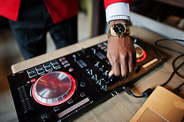 Hands of fashion african american man model DJ at red suit with dj controller.