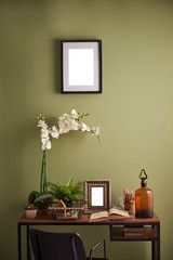 Modern green room, wooden desk vase of flower frame and picture style with book.