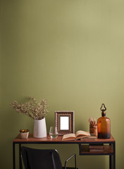 Modern room vase of flower frame and books style with green wall. Black chair.