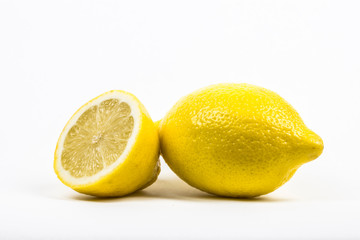 A whole lemon and a lemon cut in half. isolated in white with copy space. 