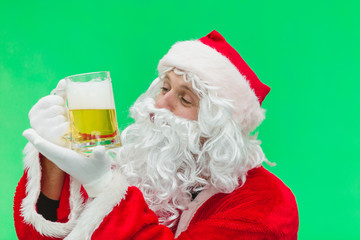 Father Christmas Santa looks at a lovely glass of beer. chroma key. close up