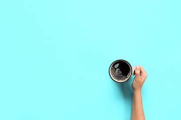 Minimalistic style woman hand holding a mug of coffee on background. Flat lay, top view