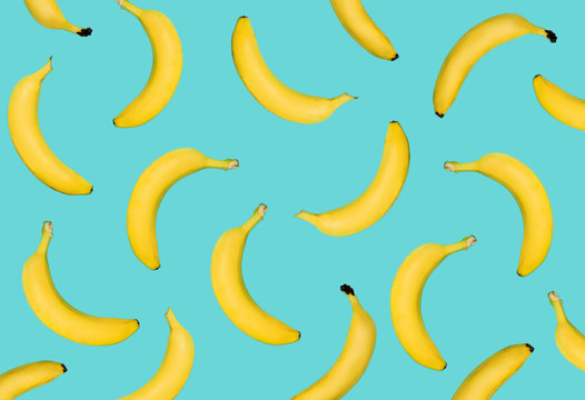 Outstanding yellow banana on pastel blue background. Fruits fall from top