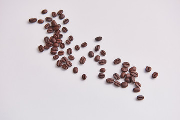 Coffee beans ont the white floor.