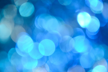 Obraz premium Bokeh photo. Holiday background. Christmas lights. background. Defocused sparkles. New Year backdrop. Festive wallpaper. Blinks. Carnival. Retro style photo. Blue.