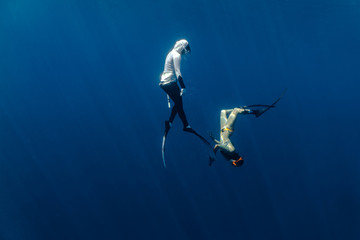 Two female free divers seen playing underwater