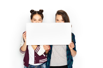 people, advertisement and friendship concept - happy smiling pretty teenage girls holding blank...