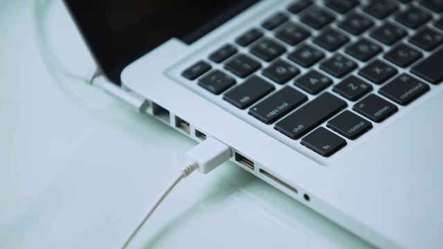 Hand connecting usb hard drive to laptop, modern personal computer technology